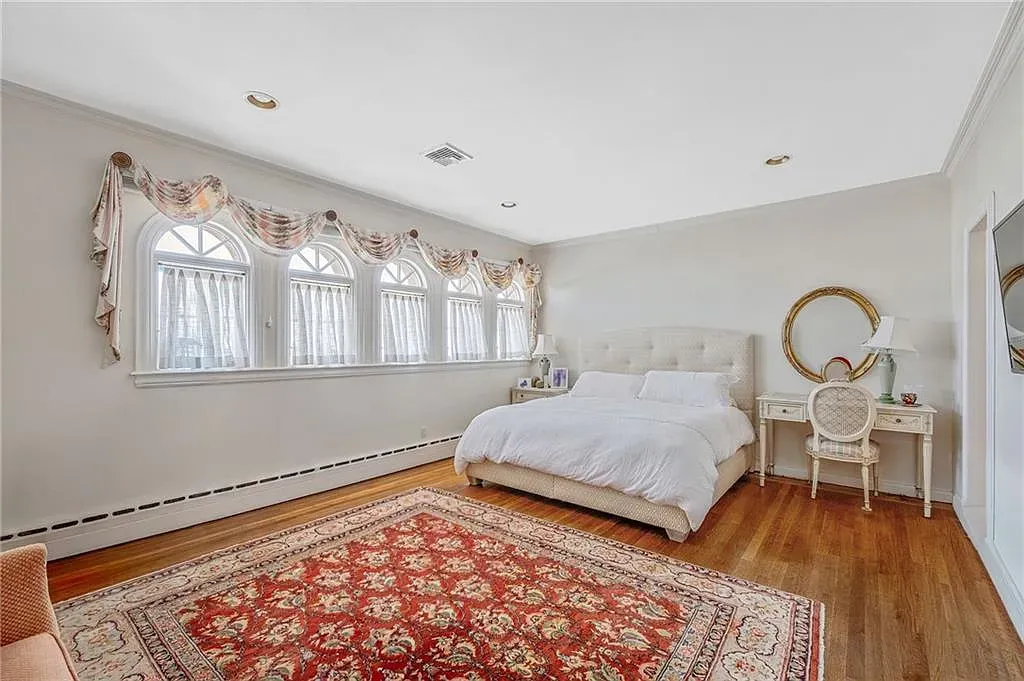Bedroom’s soft whites and earth tones, tufted headboard. Feels hotel-luxe.