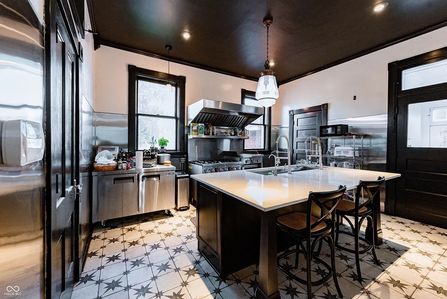 Big quartz island front and center. Dark cabinets make it feel moody-modern.