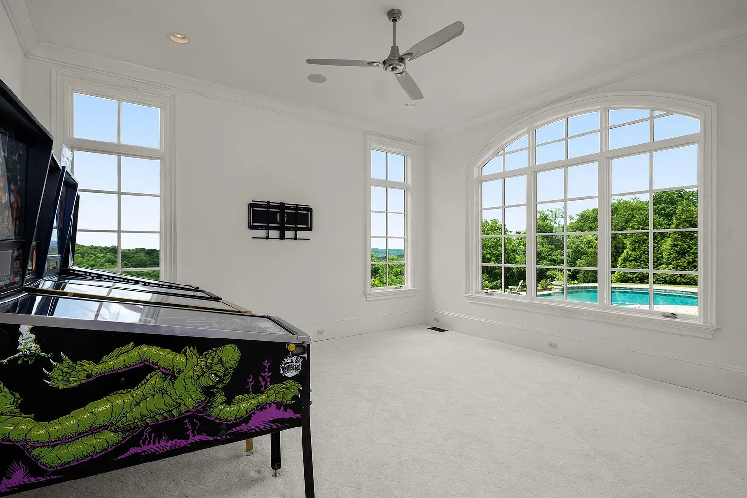 Those arched windows flooding everything with light, looking straight out at the pool.