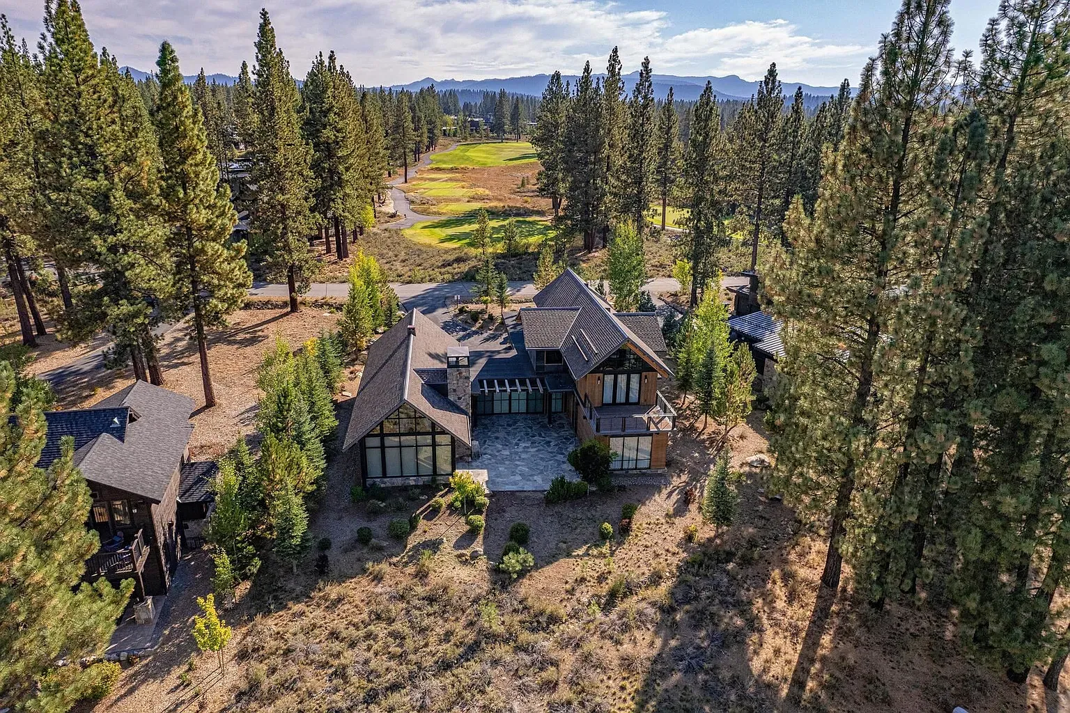 Forest backdrop on all sides. Dark wood and glass make it disappear nicely.