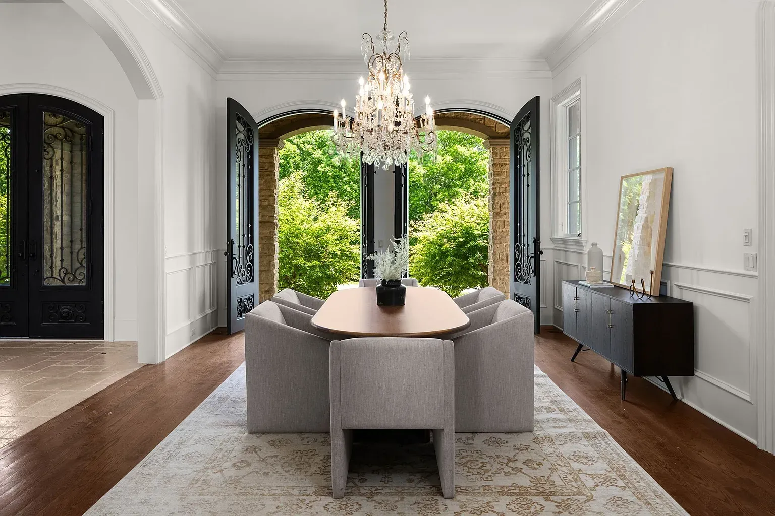 Long wood table, plush gray chairs. Feels actual dinners happen here.