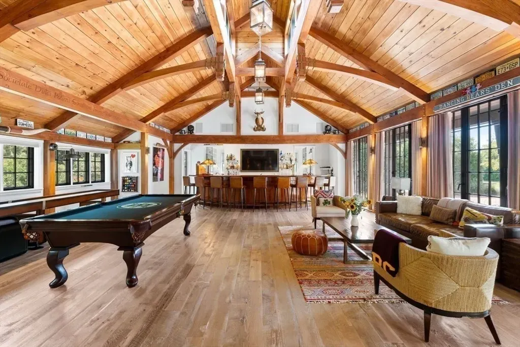 Vaulted rec room with fancy beamwork. Looks movie nights plus board games.