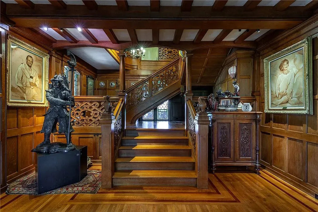 That staircase carving goes crazy. Warm wood everywhere, very old-school grand.
