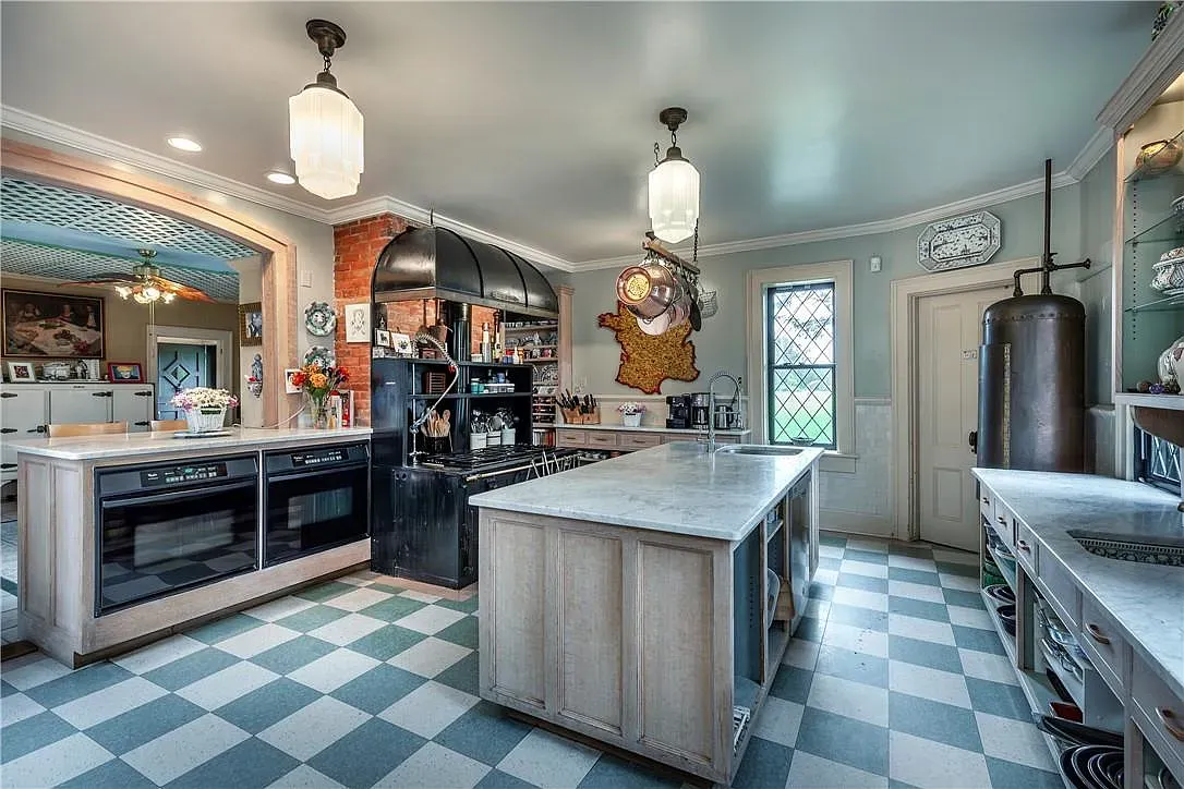 This kitchen’s marble island is massive. Soft paint, vintage hardware, very usable.