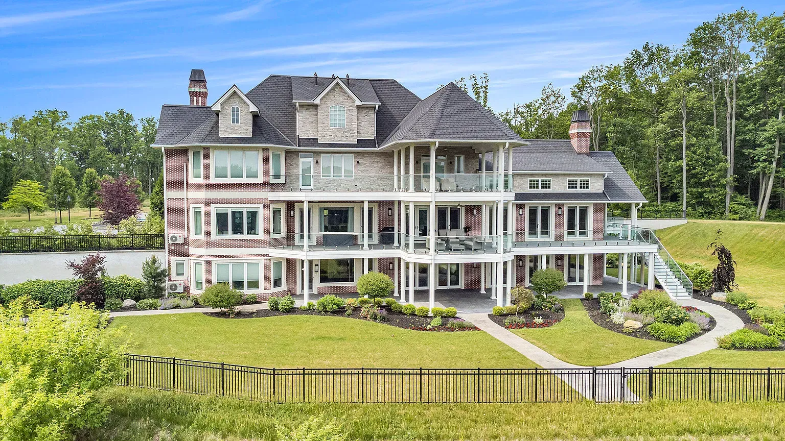 Mixed brick-and-stone facade, gables and dormers stacking up nicely. Looks expensive.