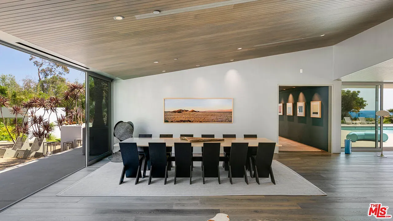 Long table, ten black chairs lined up. Big dinner energy without being fussy.