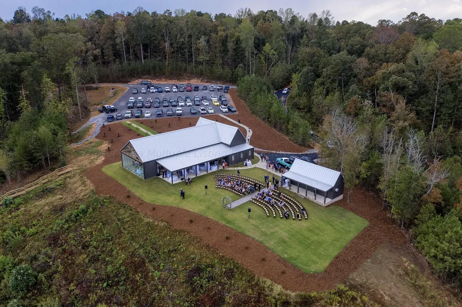 Steel and glass pavilion vibe. Light gray with shiny roof catching the sun.