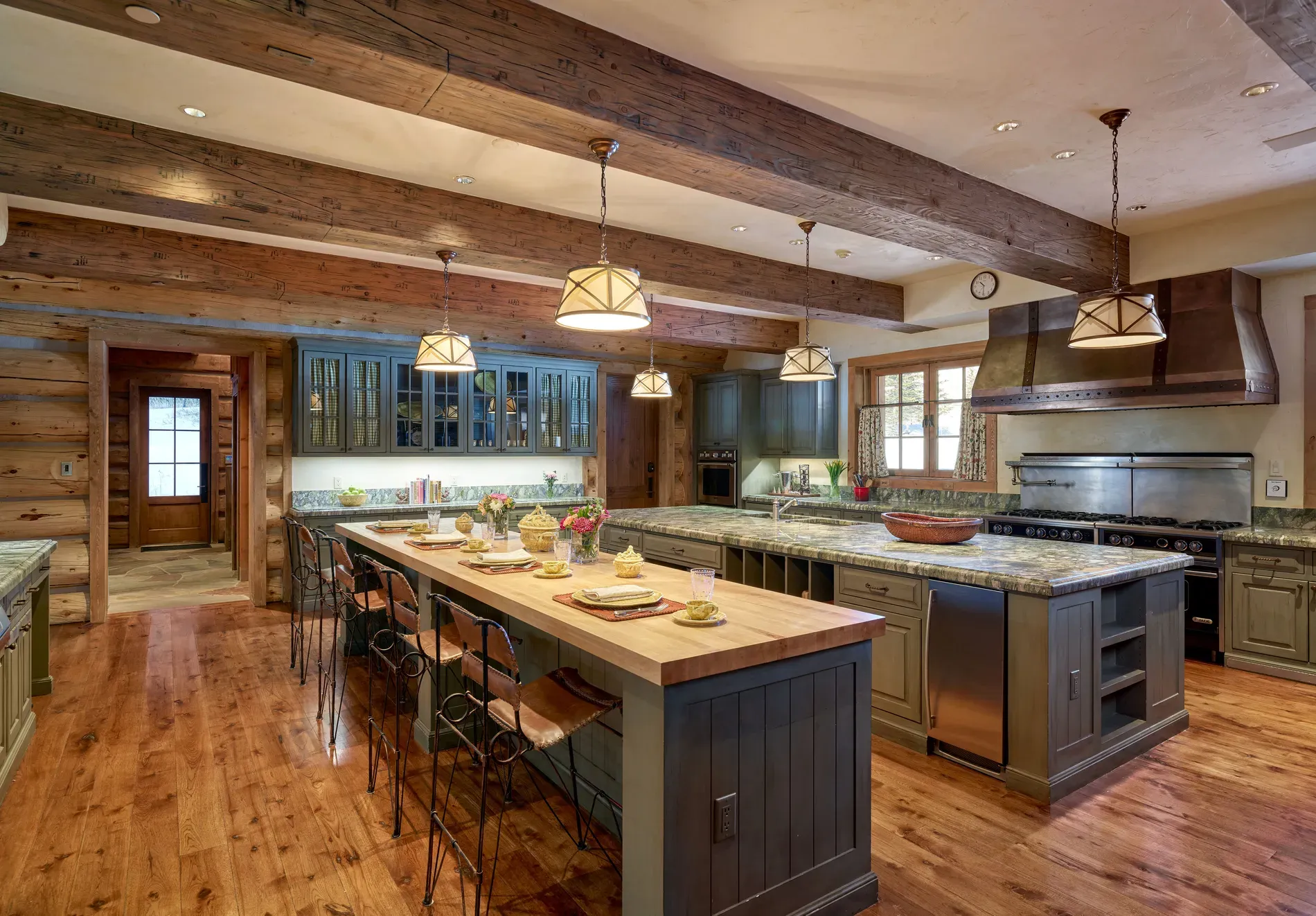 Here's the kitchen — wide planks, beefy beams, big island. Very gather-y.