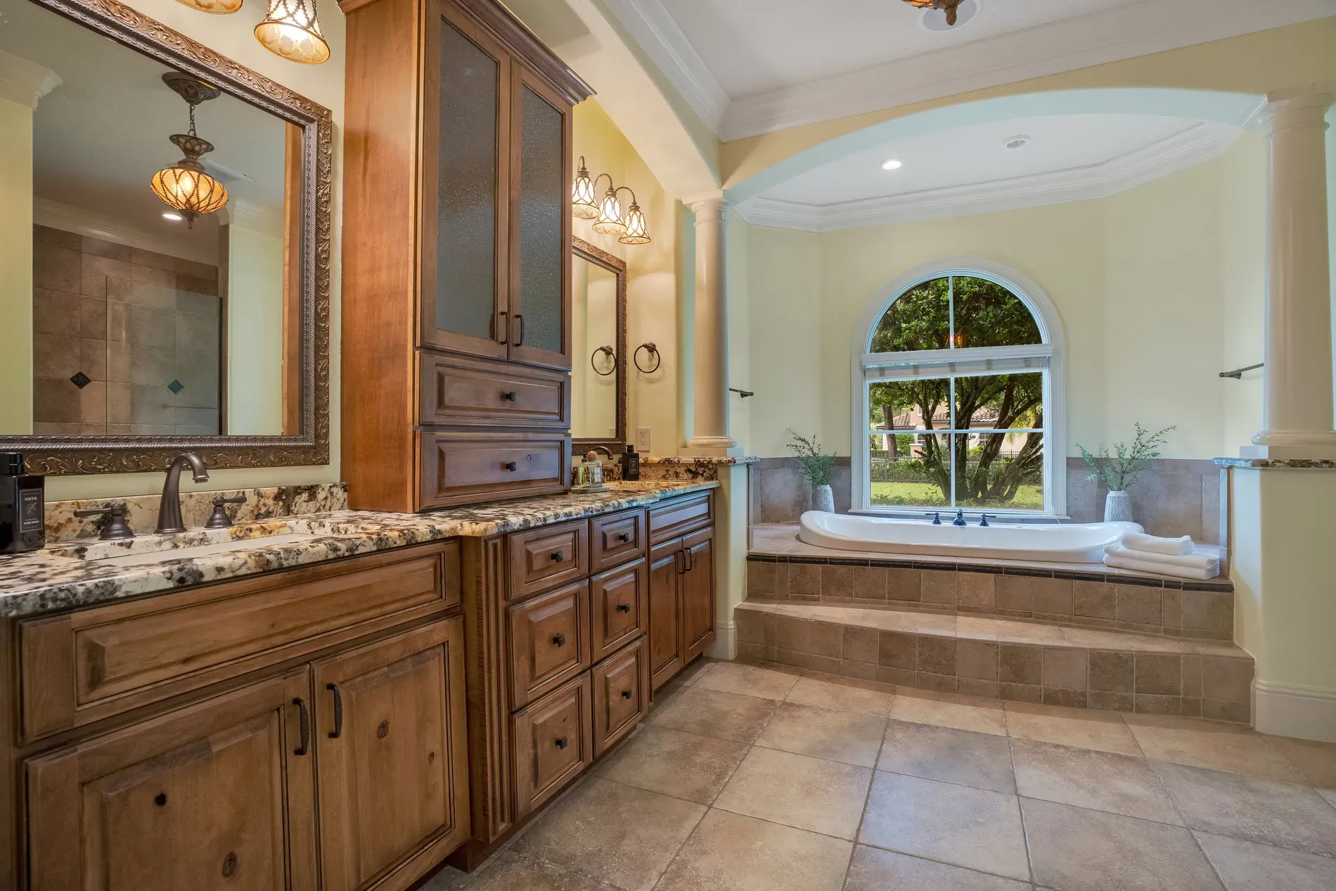 Bathroom. rich wood cabinets, fancy pulls, soft yellow walls. Pretty classic.