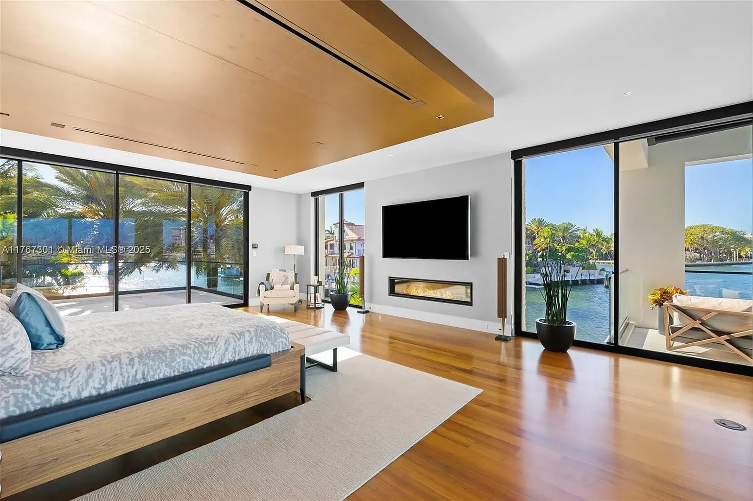 Floor-to-ceiling glass in the bedroom. Wake up to palms and water.