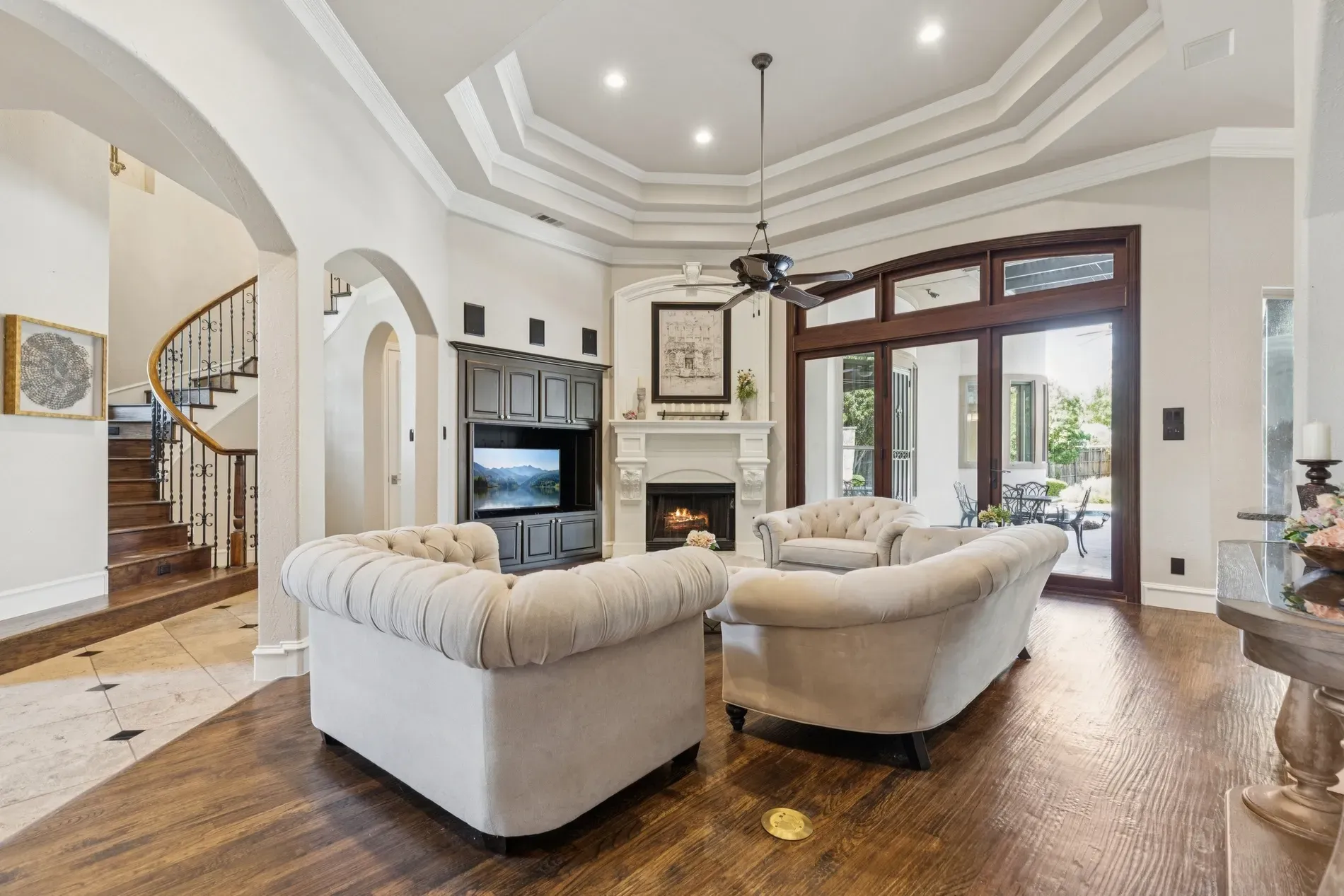 Here's the living room — coffered ceiling, soft whites, big fireplace situation. Calm and classic.