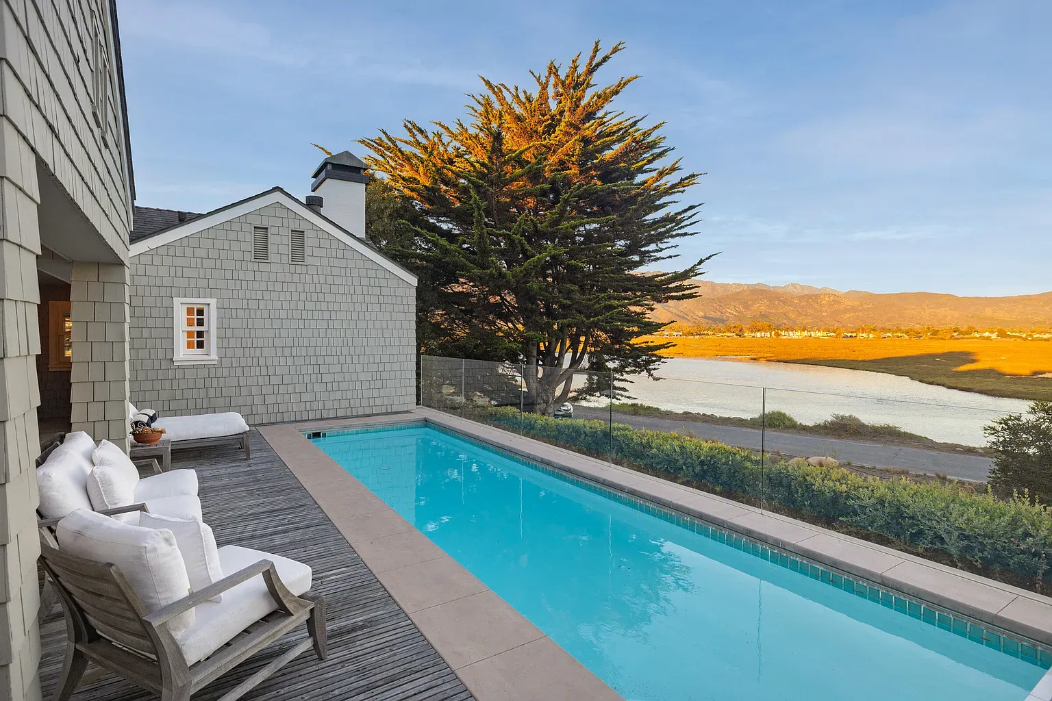 Pool looks a postcard. Turquoise water, wood deck, trees wrapping around.