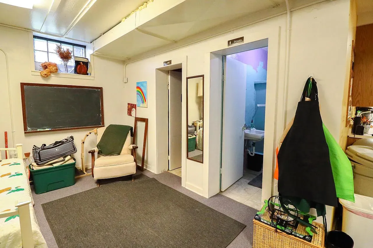 Different room goes softer. beige walls, plush gray carpet, easy hangout energy.