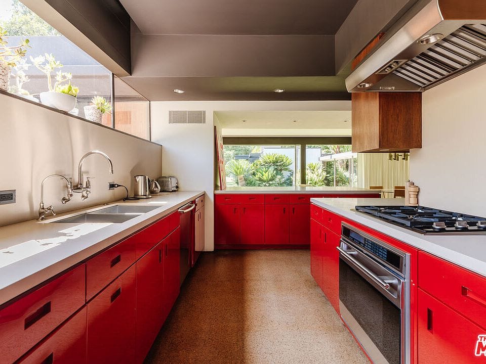 Red cabinets are loud in the best way. Clean counters keep it calm.