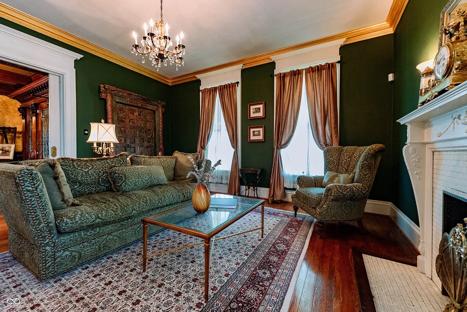 Deep green walls with gold crown molding. The chandelier seals the deal.