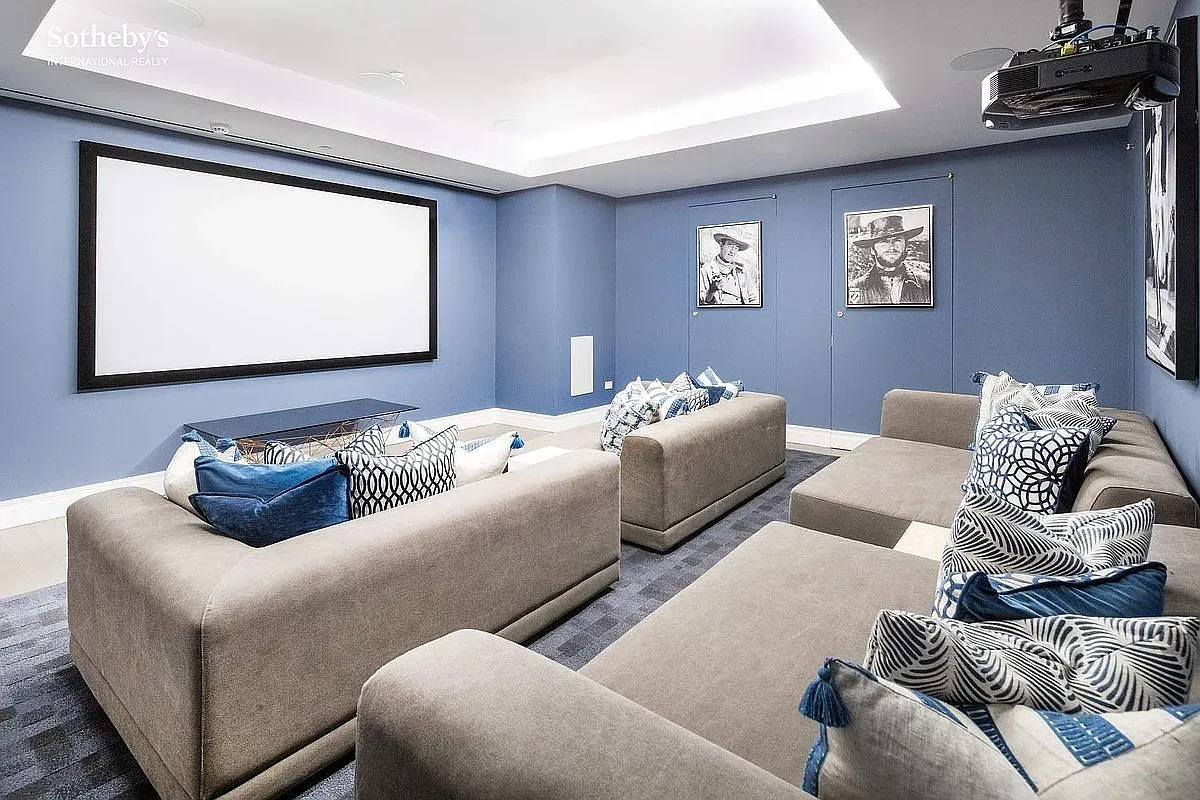 Home theater in pale blues, huge sectionals, piles of pillows. Nap trap.