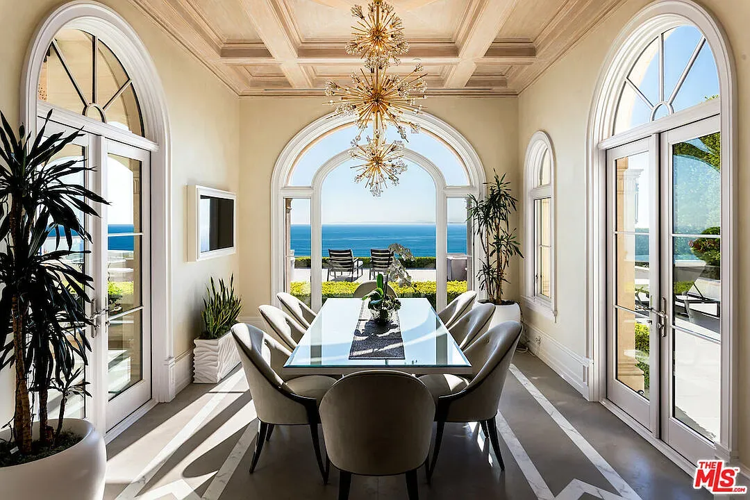 Dining with arched windows framing the sea. Calm, fancy, not trying too hard.