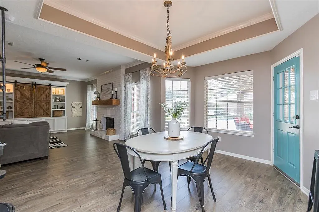 Round white table, black chairs, gray walls. Simple and sharp. Love the pendant.