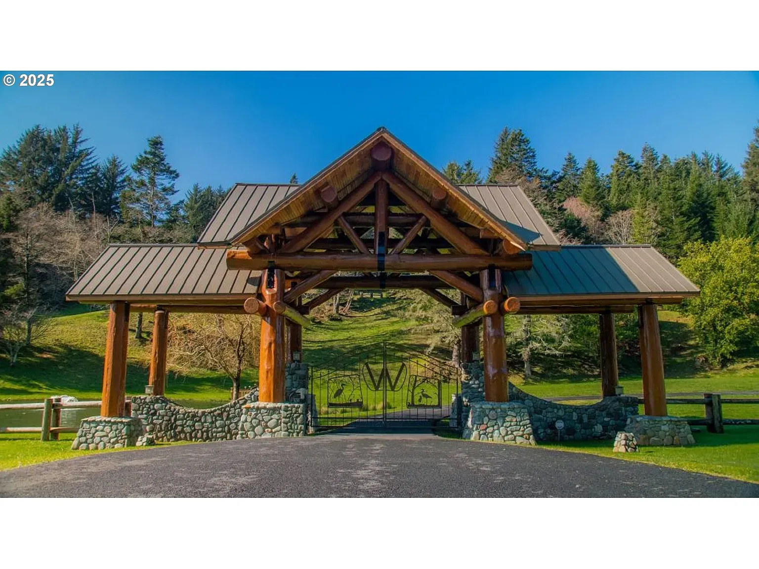 Driveway gate looks its own mini lodge. Big timbers everywhere.