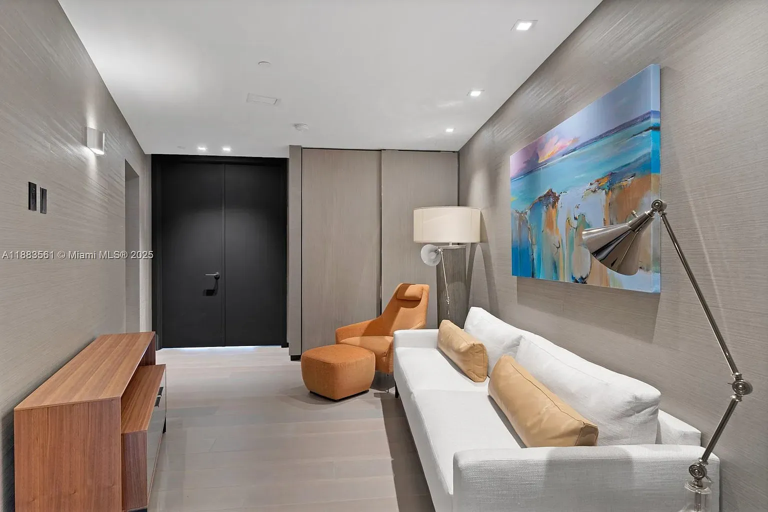 Entry’s quiet and clean. Fabric walls are a fancy surprise — why fabric?