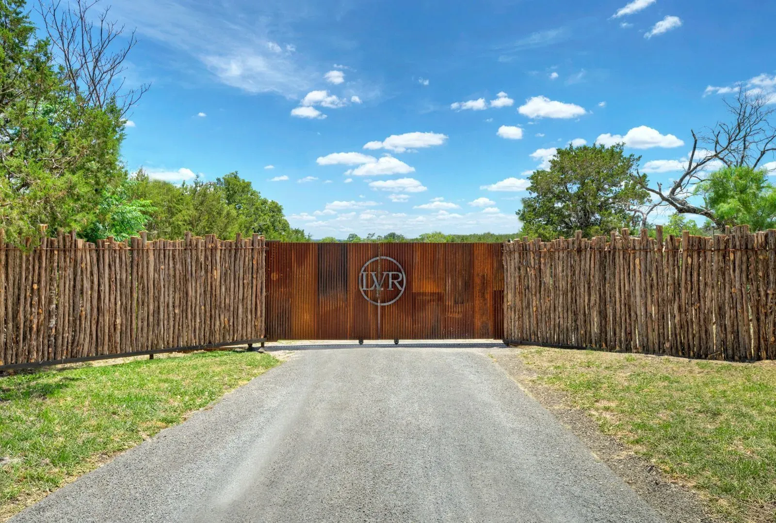 Entrance gate goes full medieval ranch. That emblem though—family brand or logo?