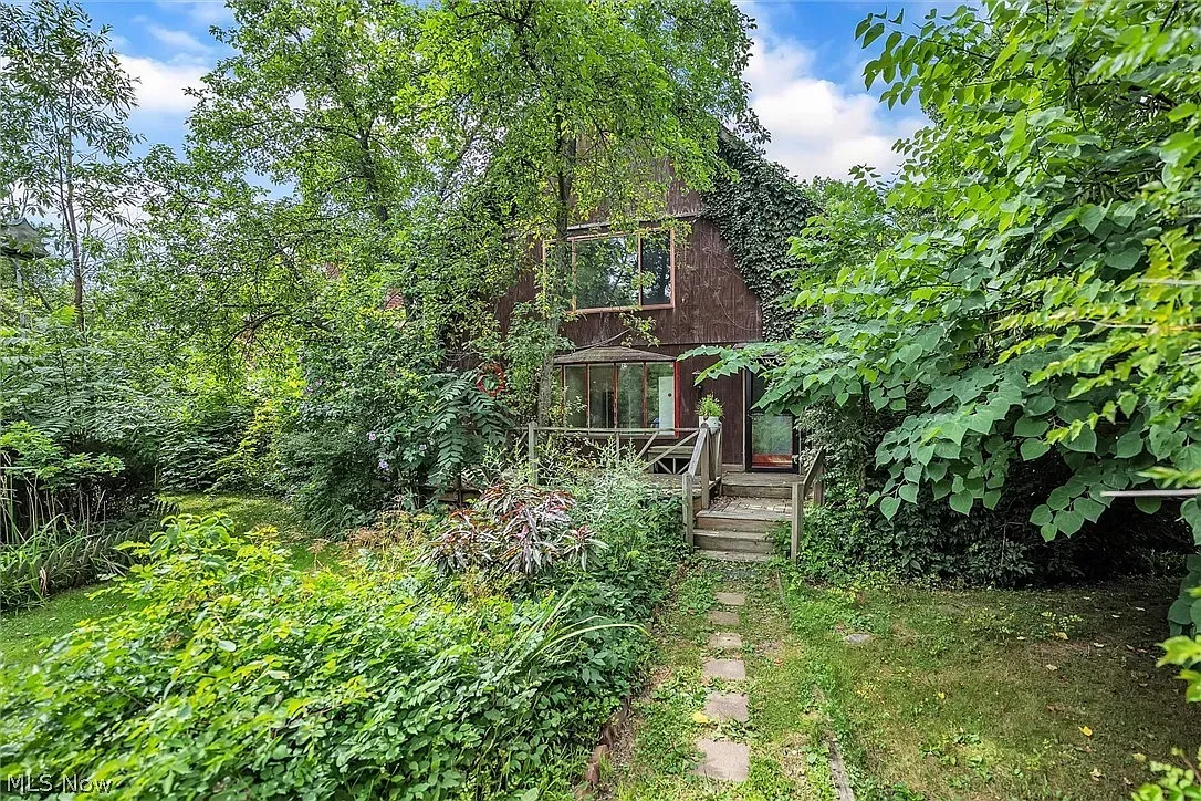 Wood-clad exterior tucked in greenery. Massive windows stealing the show.