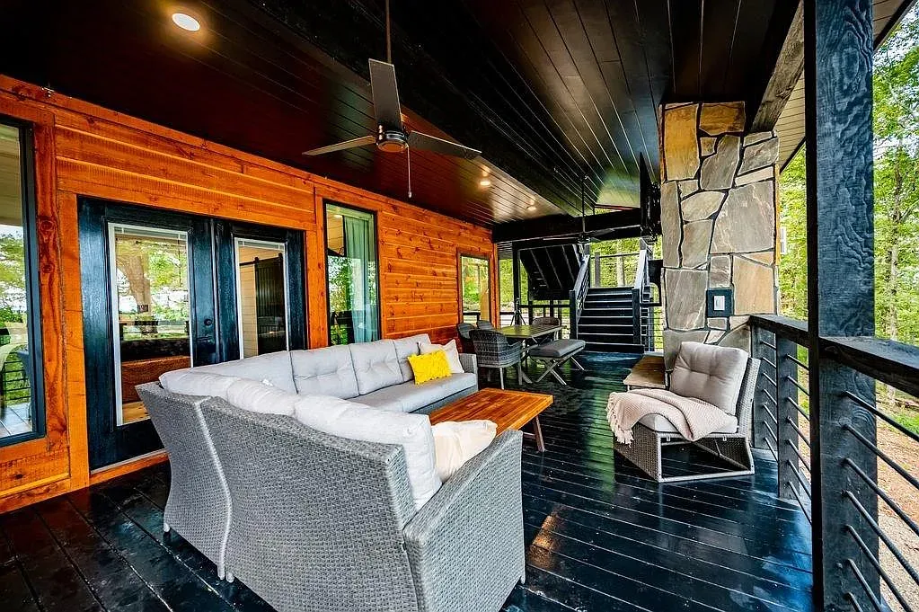 Covered porch with warm wood and a black ceiling. Looks the hangout.