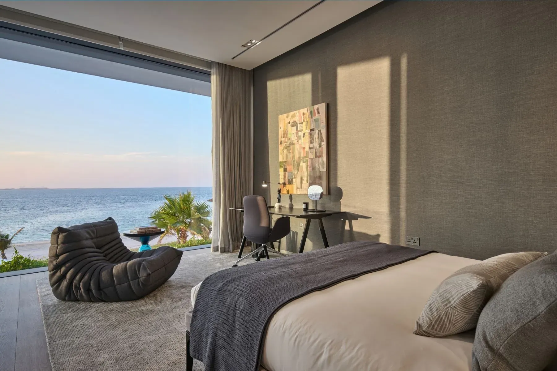 Another ocean-facing bedroom. Taupe walls, giant window, no art needed.