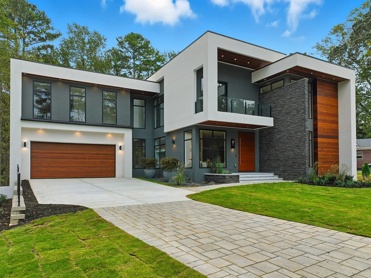 Different angle outside. white stucco, vertical wood, some stone. Warm but modern.