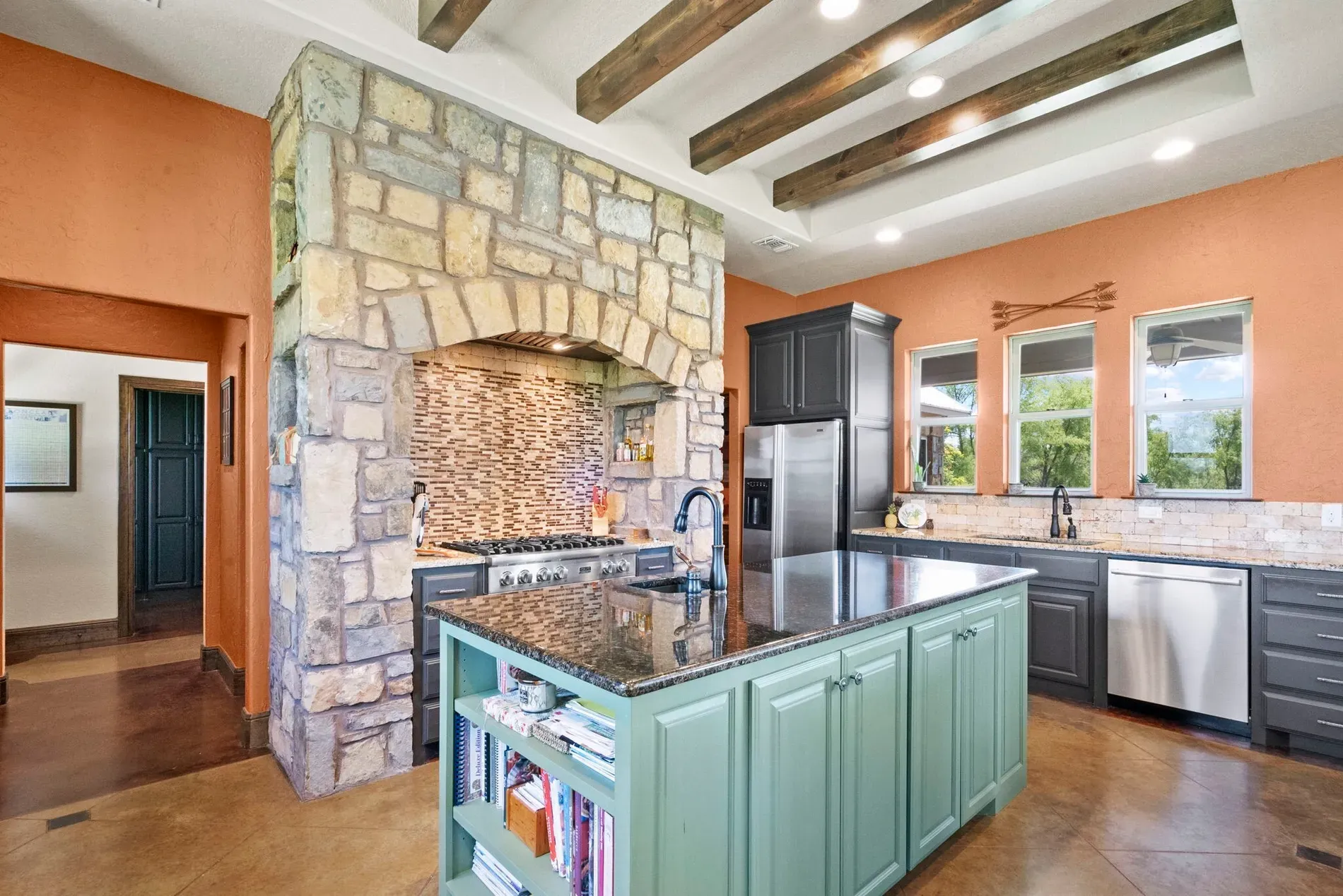 Another angle of the stone wall kitchen. Massive range, serious chef energy.