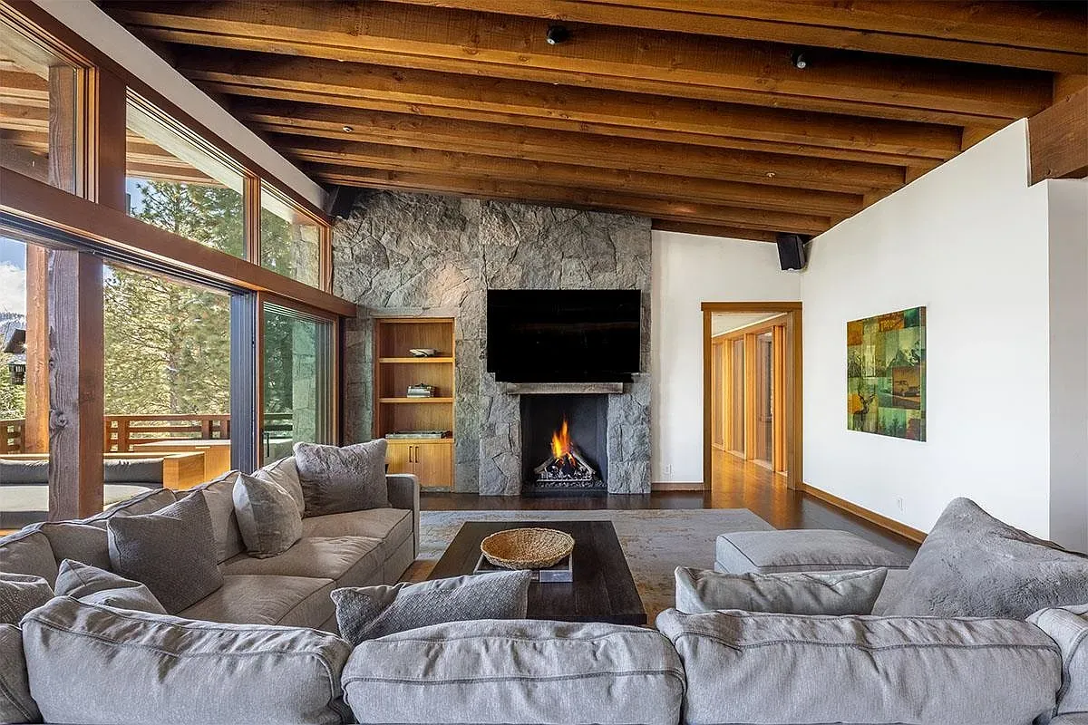 Double-height living room, exposed beams, fireplace moment. Cozy without losing the modern lines.