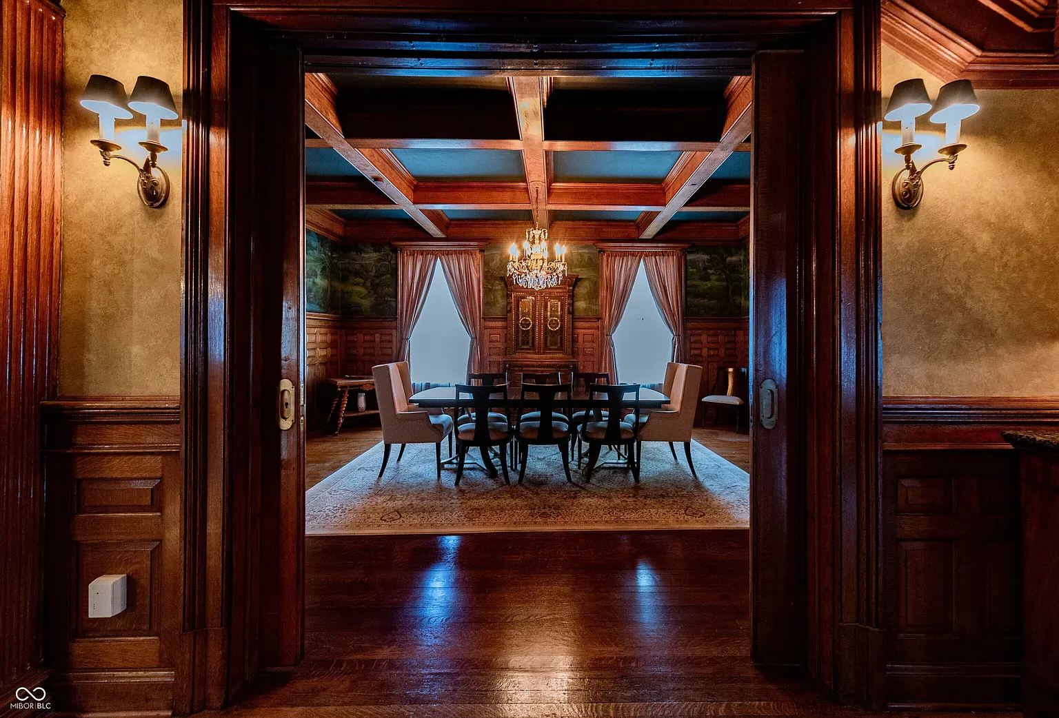 Dining room with wood paneling and big doorways. Feels a movie set.