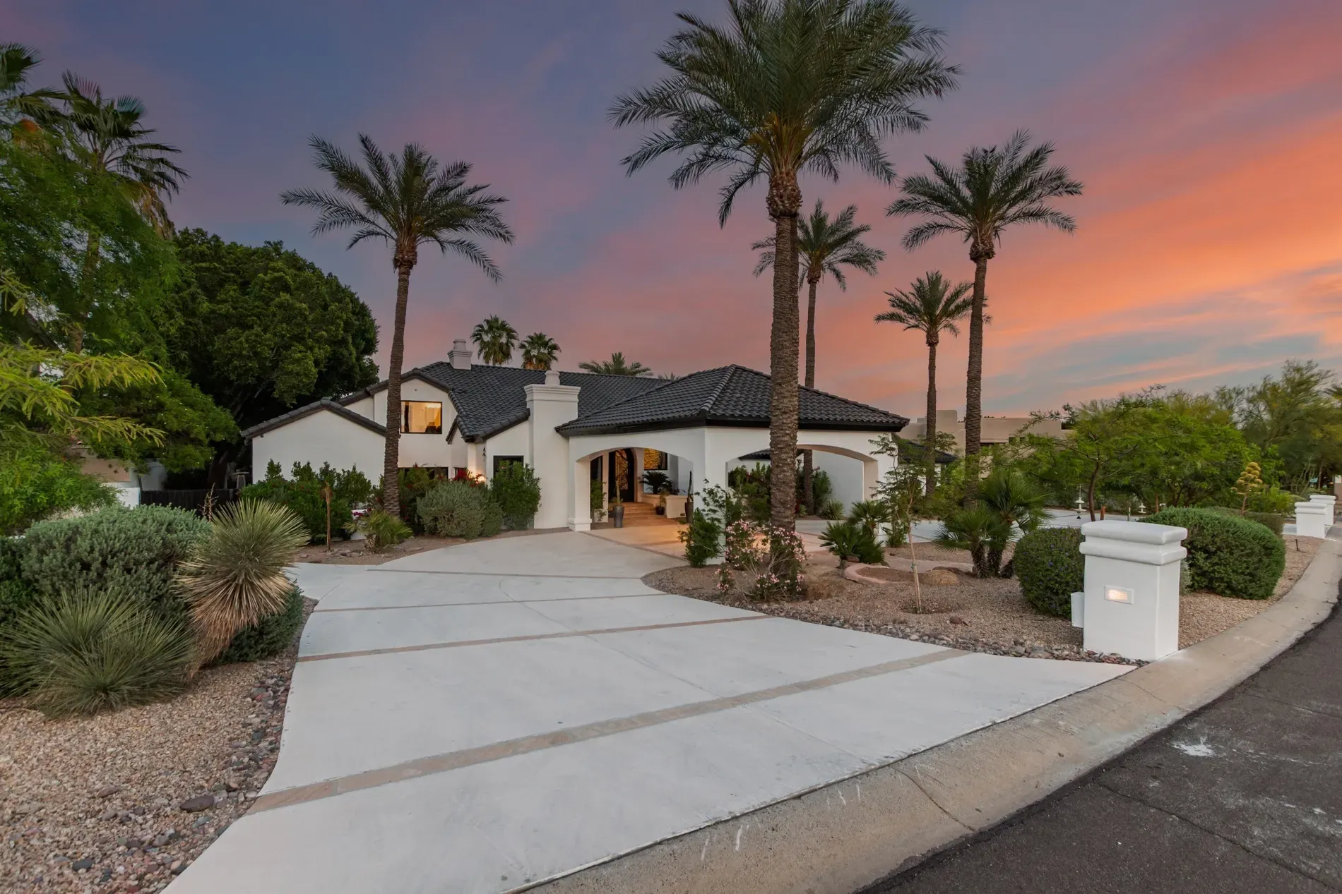 Mediterranean-ish front — white walls, charcoal tiles, palms swaying. Dramatic sunset helps.