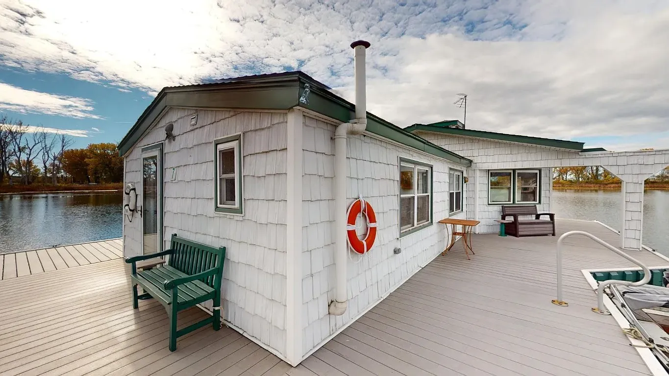 White shingles with a dark green roof. Little boathouse look, very sweet.
