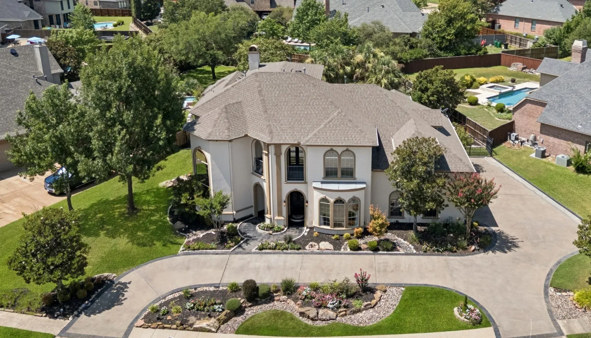 Here's the front — creamy stucco, arches, big windows. Classic hipped roof vibes.