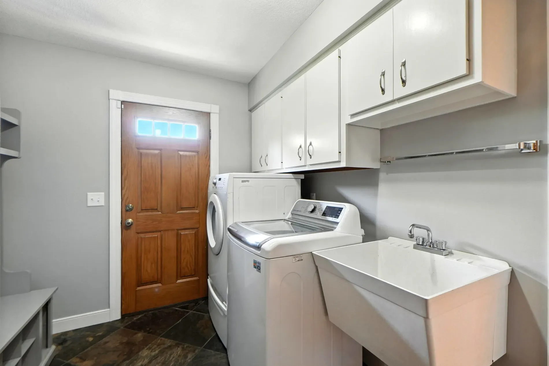 Laundry room’s tidy. Love the wood door. Where’s the folding space though?