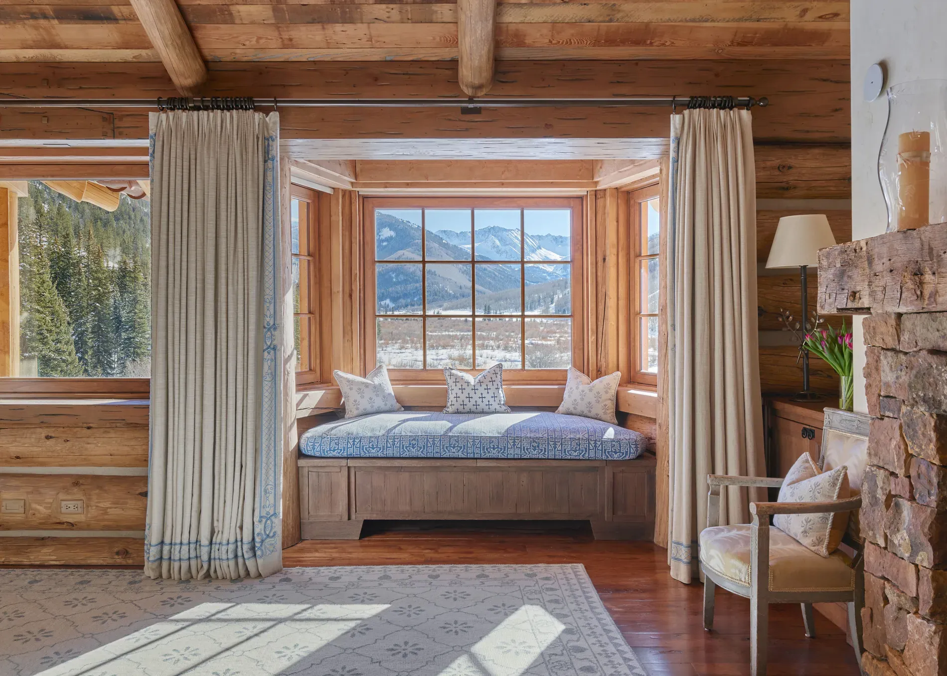 Reading nook between huge windows. Mountain wallpaper, but real. I’d live here.