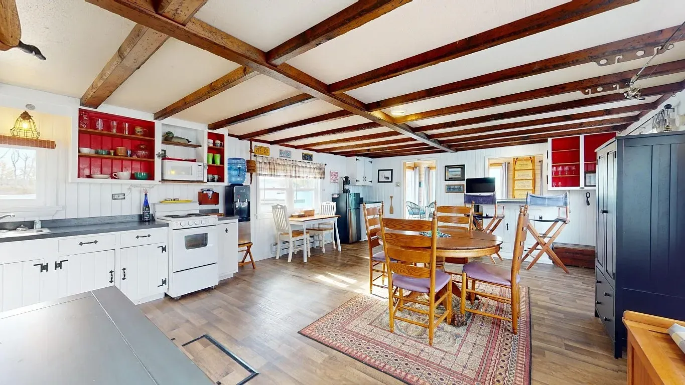 Open kitchen/dining with crisscross beams. Feels rustic without being heavy.