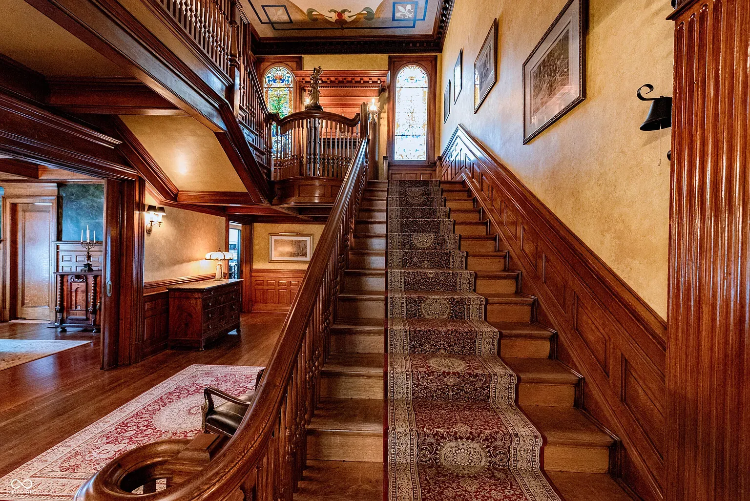 That staircase sweep with the carved banister, instant drama right off the entry.