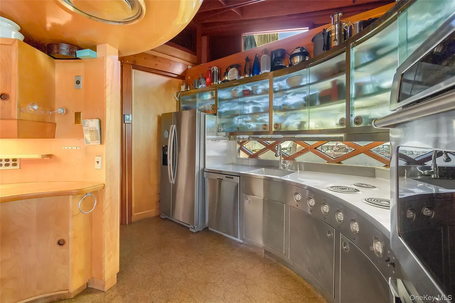 Curvy kitchen is wild. Honey wood cabinets actually make it feel cozy.