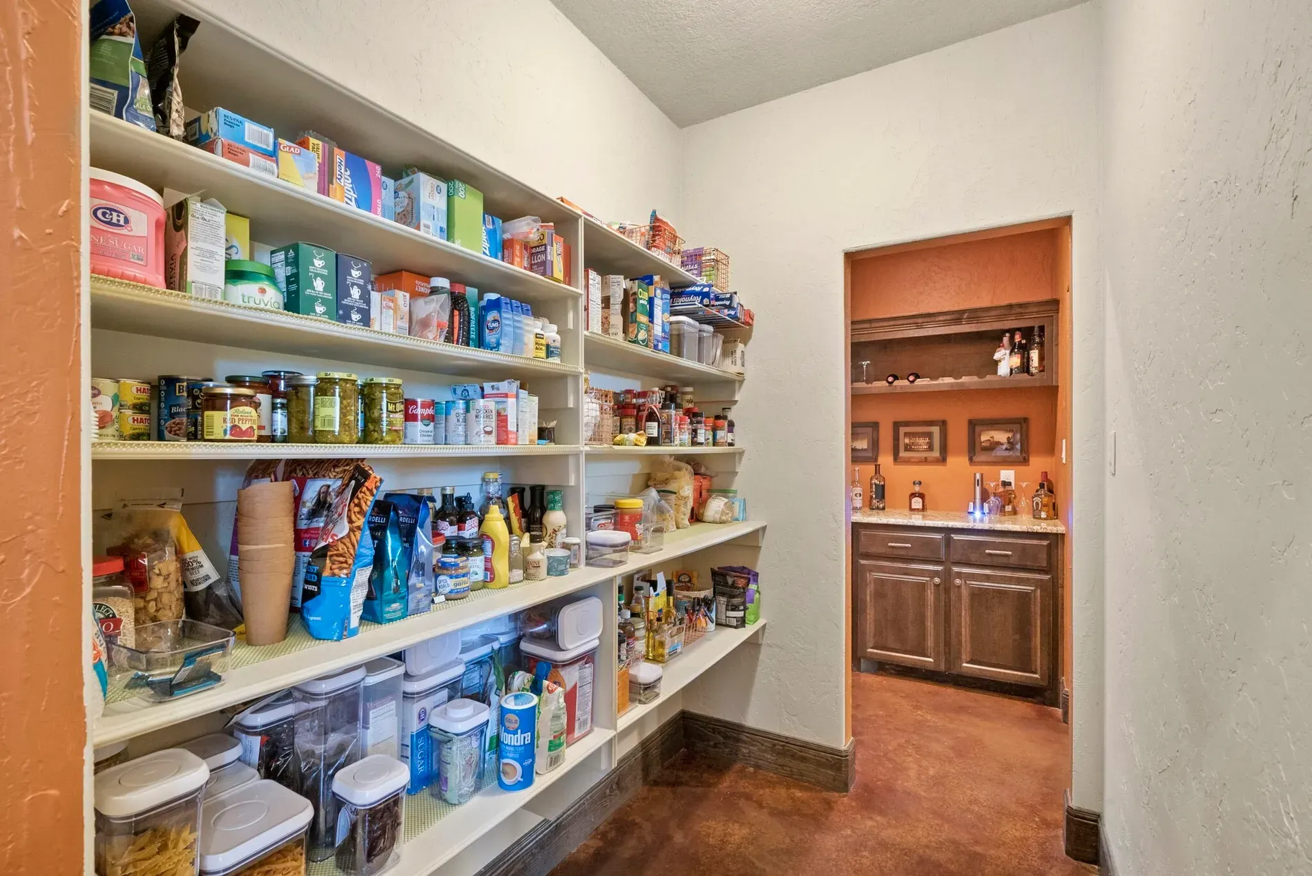 Pantry goals. white open shelves, jars lined up, everything actually has a spot.