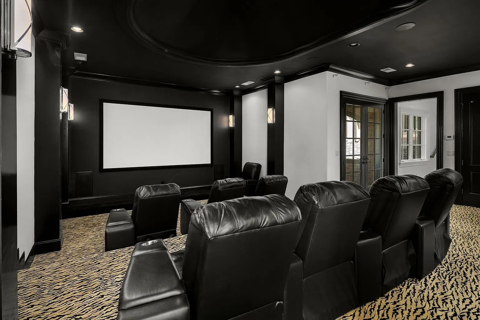 The theater goes full blackout with a curved ceiling. Serious movie night energy.