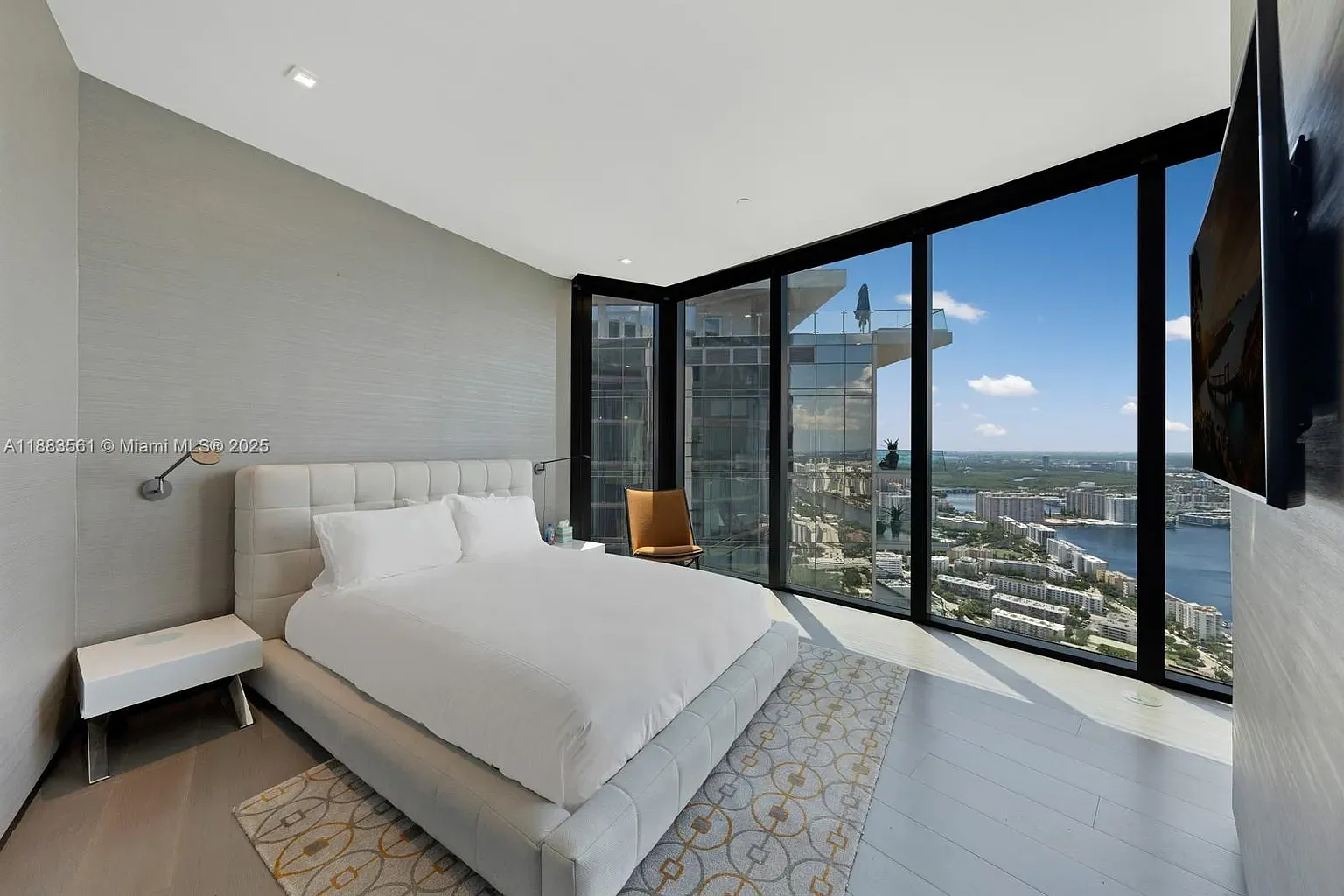 Bedroom goes full panorama. City and water right there. Walls look super plush.
