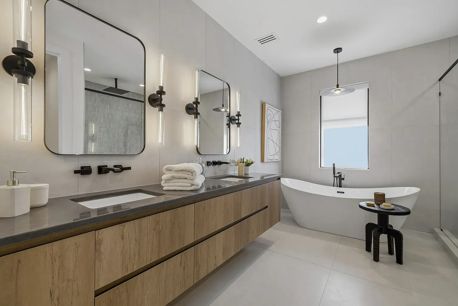 Bathroom pulls off warm wood with dark fixtures. Long vanity, clean lines.