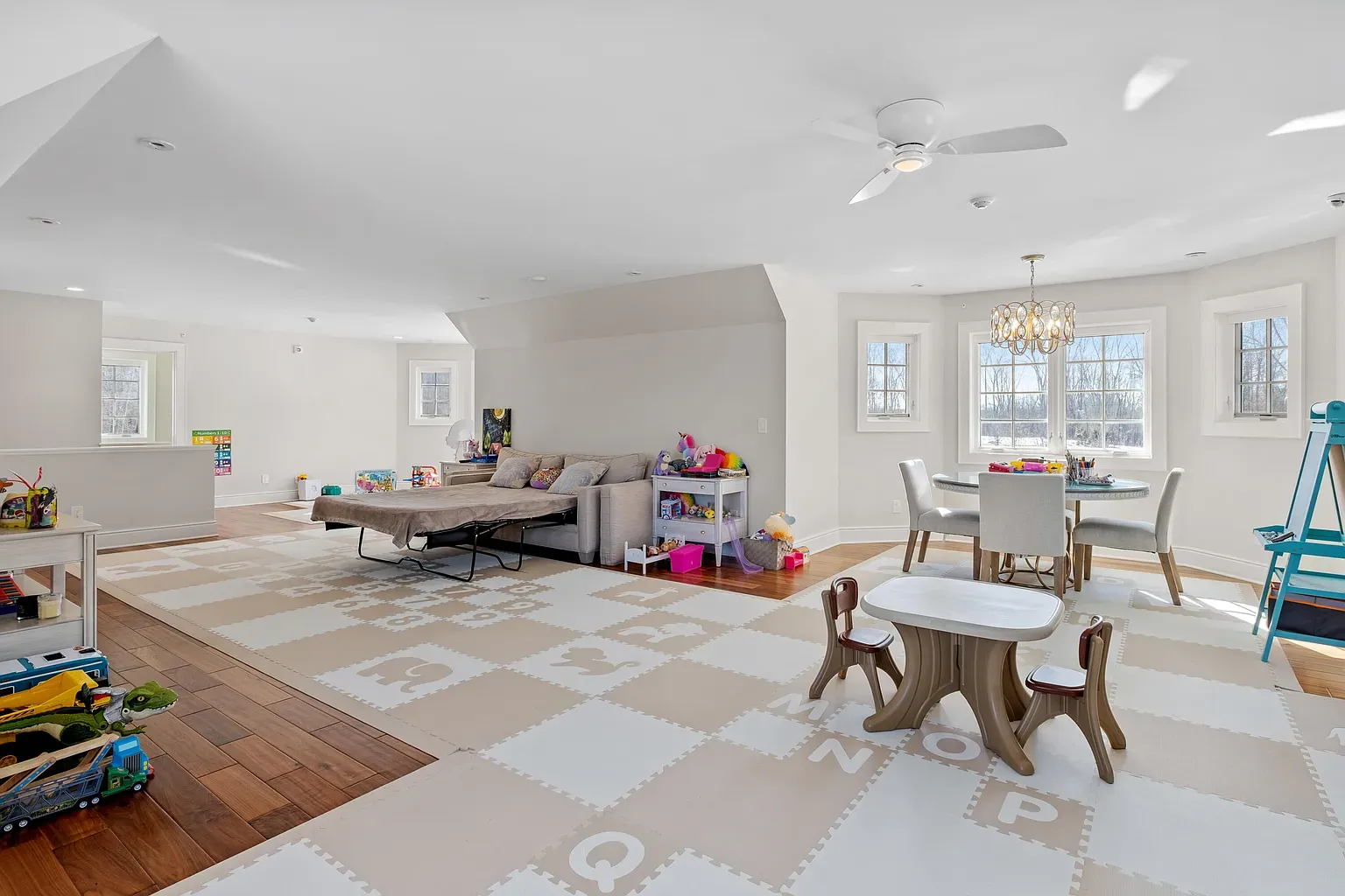 Sunlit hangout room. big windows, neutral walls, lots of floor space for chaos.