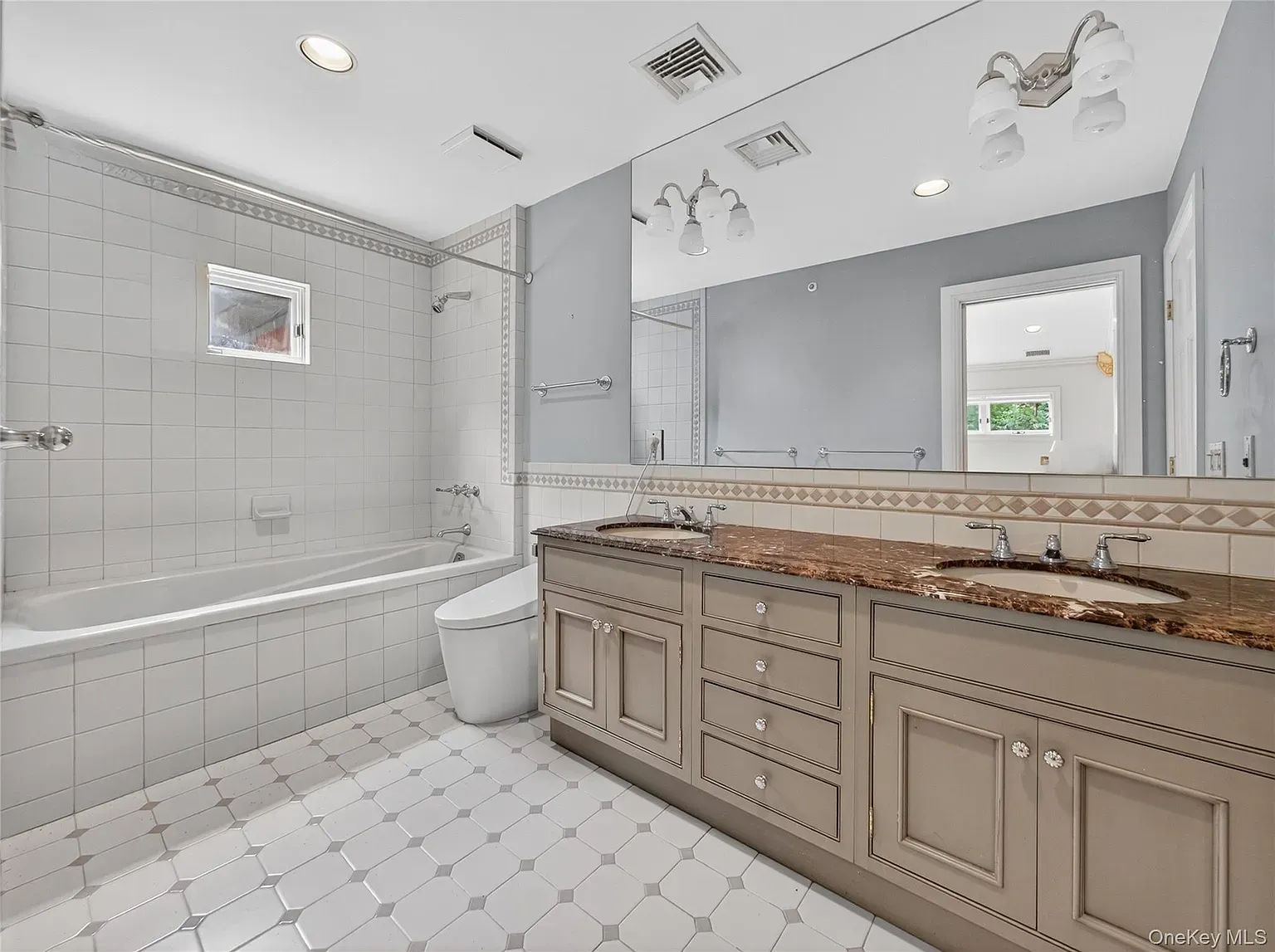 Calm, clean bathroom. Big off-white tiles make it feel extra open.
