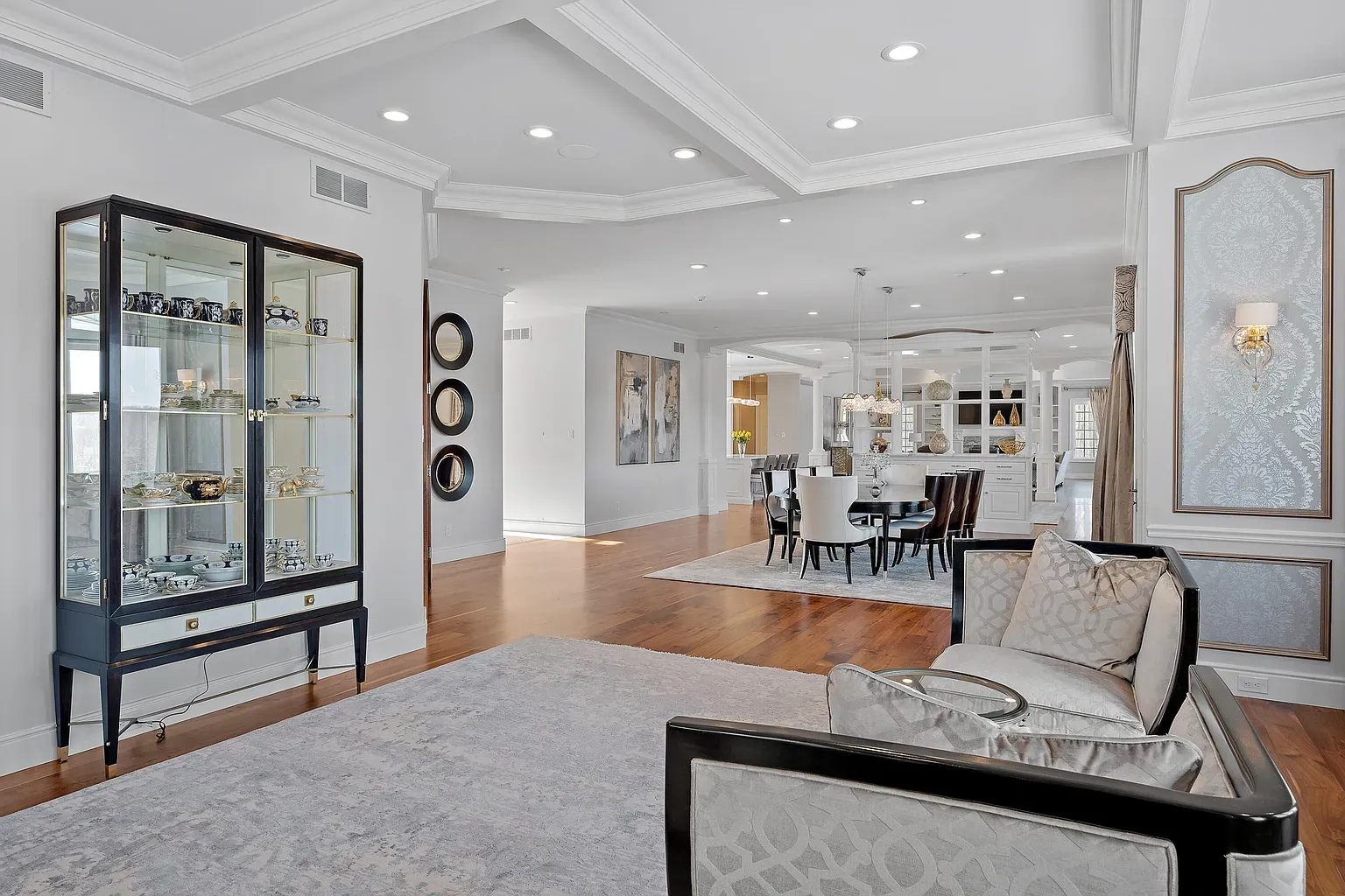 Open living room with glossy hardwood and soft grays. Clean and calm.