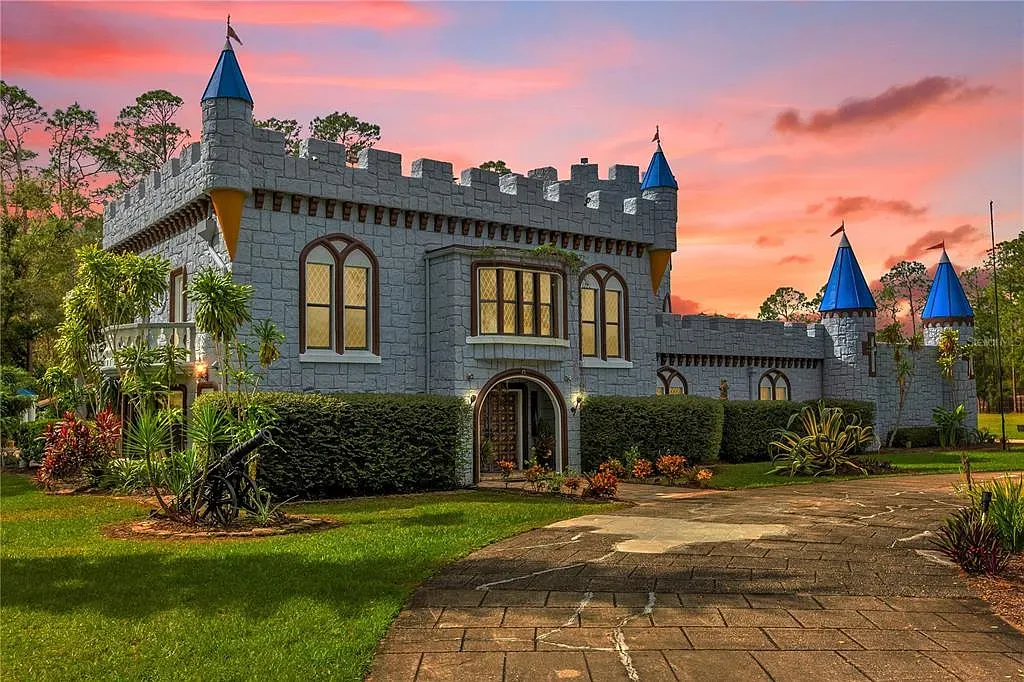Stone fortress front with battlements. Looks a castle, but landscaping is tidy.