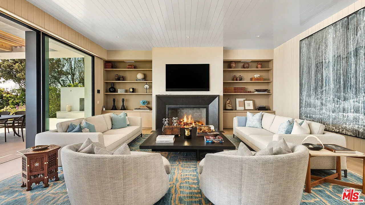 Cozy seating around a dark stone fireplace. Ceiling detail quietly flexes.