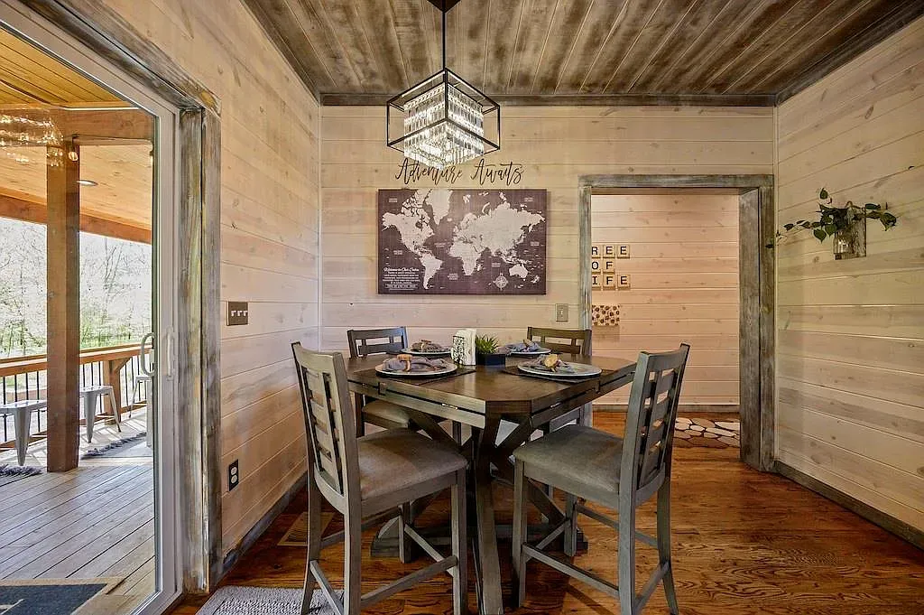Dining room brings in light wood walls and chunky dark ceiling beams.